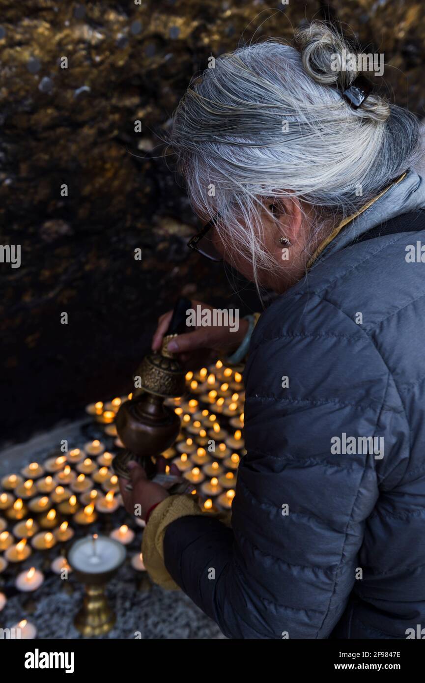 India, Bodhgaya, Mahakala cave, Dungeshwari, senior citizen, sacrificial candles, Stock Photo