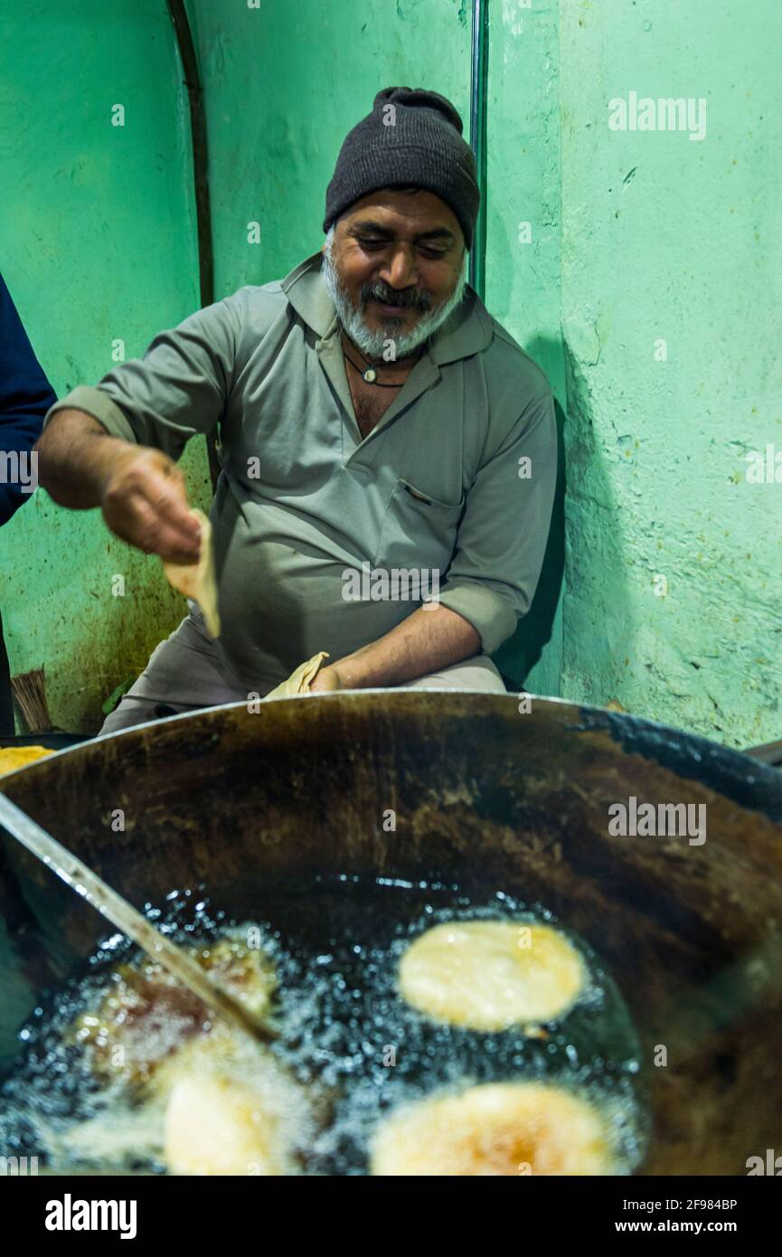 India, Varanasi, scenes in the old town, man, dough, baking, drip pan Stock Photo