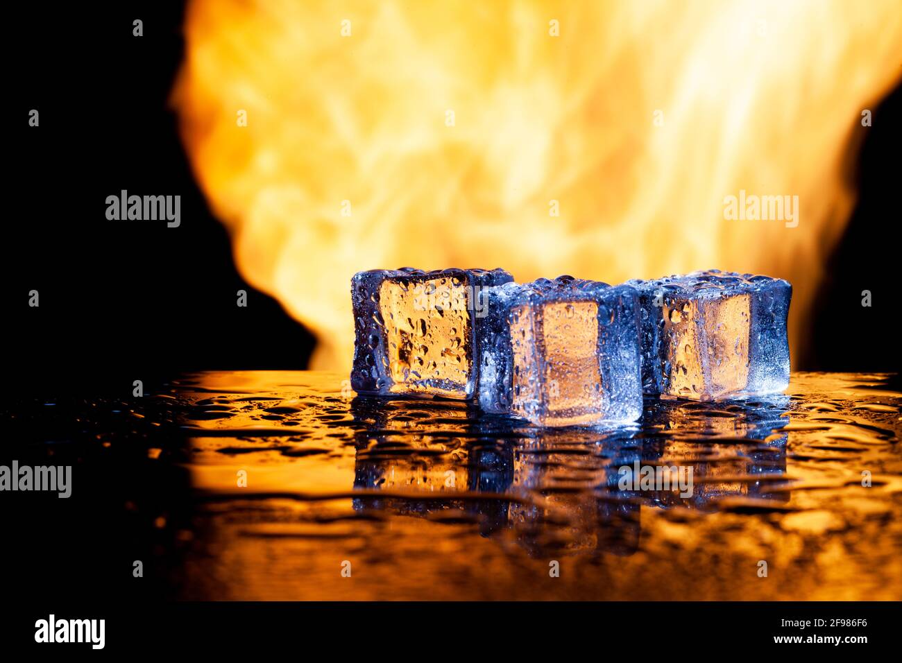 ice cubes on a black background in flames Stock Photo - Alamy