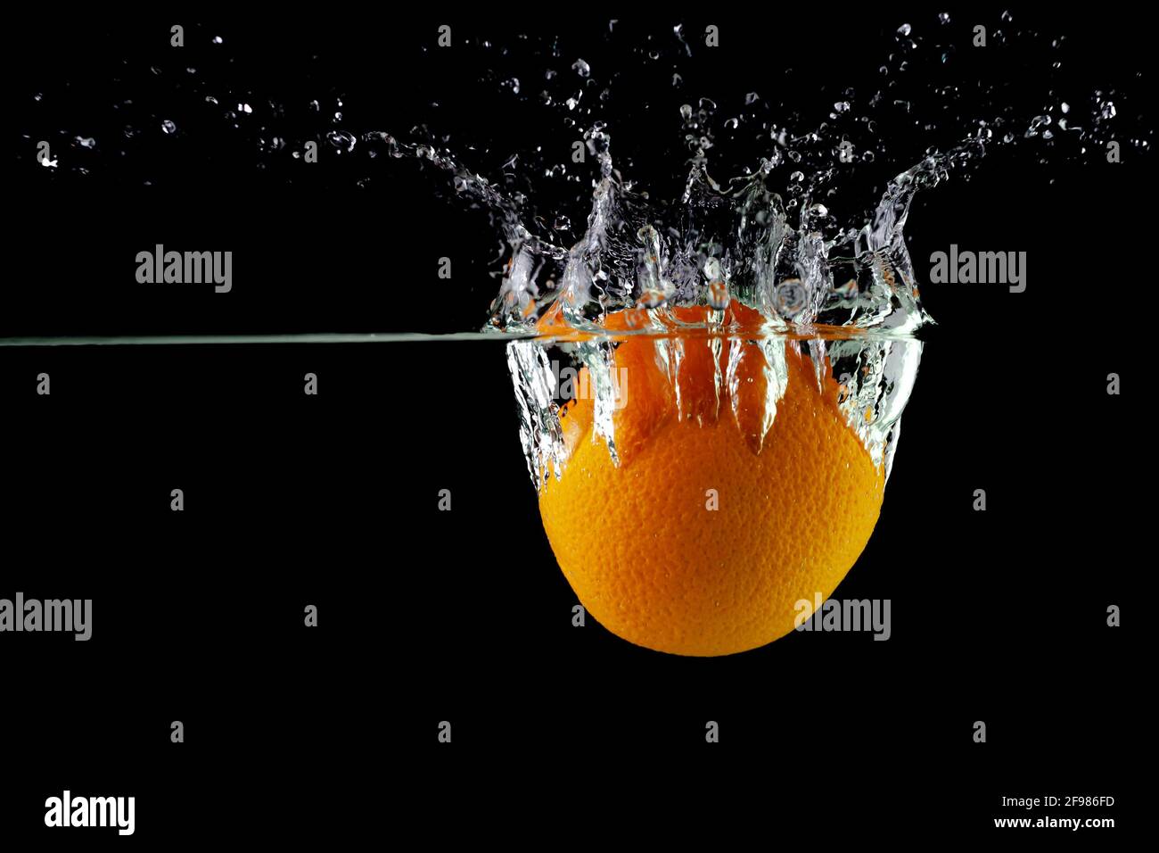 tangerine in water on a black background, place under the text Stock