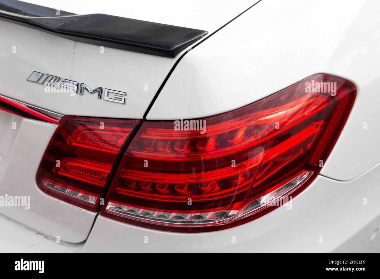 The Rear Quarter Light And AMG Badge With Carbon Fibre Brabus Rear Spoiler Of A 2013 Mercedes Benz E63S AMG W212 Stock Photo