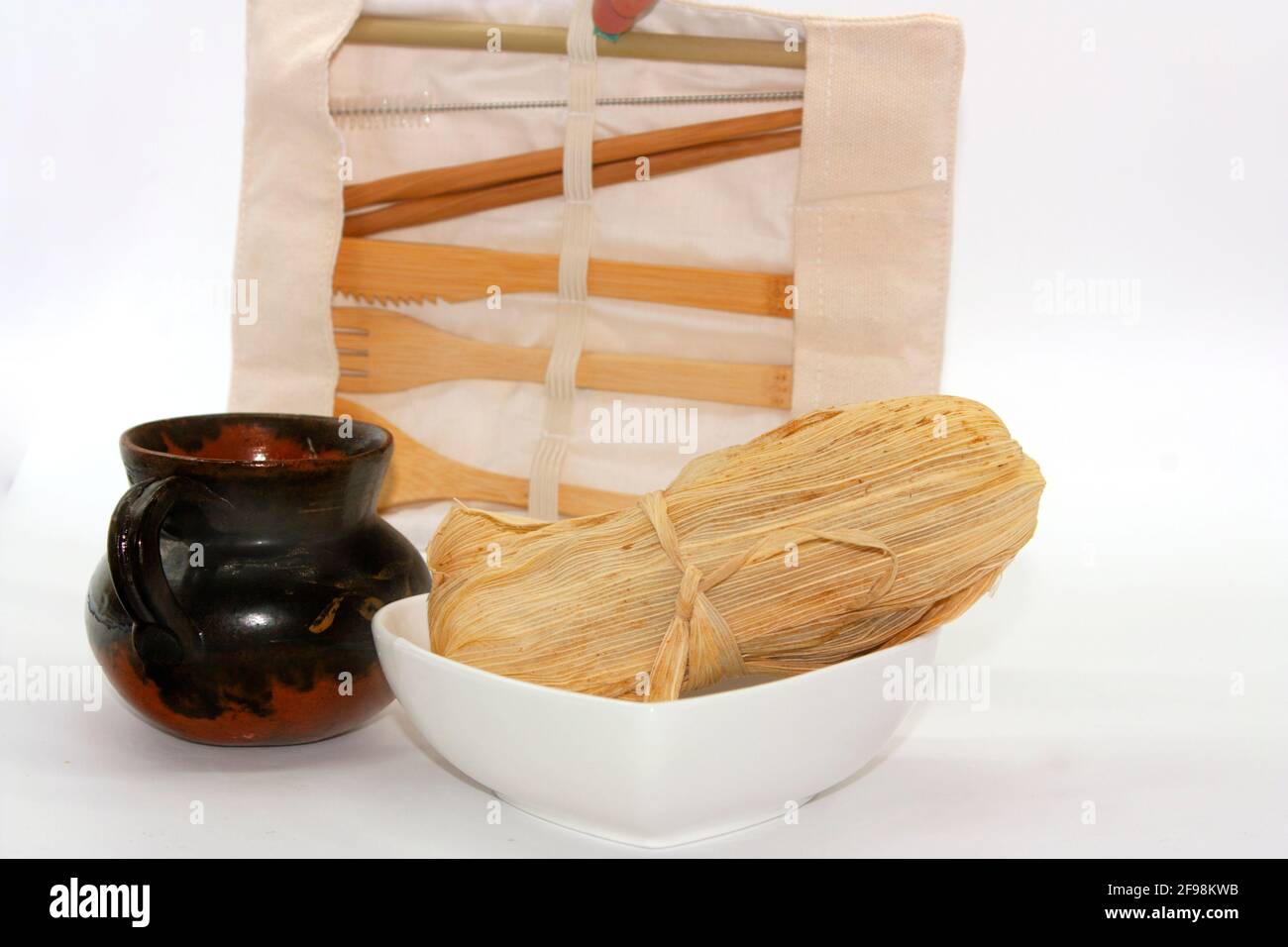 Wooden fork and knife for tasting tamale wrapped in corn joja and black