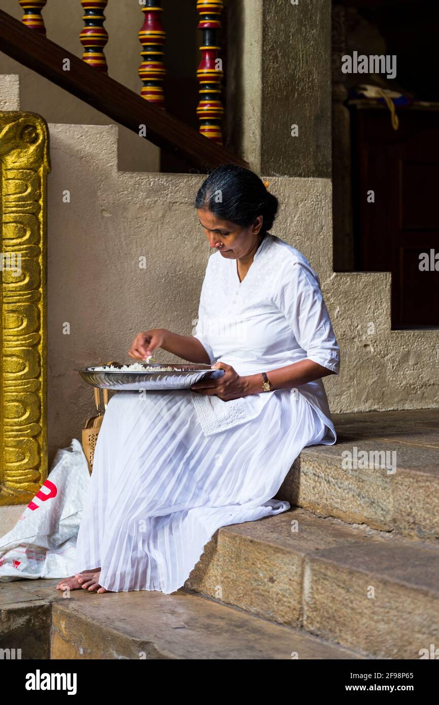 Sri Lanka, Kandy, Sri Dalada Maligawa, the Temple of the Sacred Tooth, elderly woman, rice bowl Stock Photo