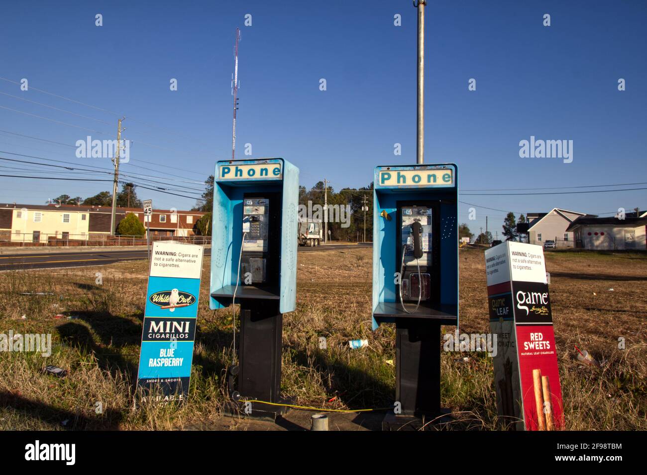 Augusta, Ga USA - 02 24 21: Old 80’s style coin operated payphone Bellsouth Tobacco ads and litter and waste on the ground in an urban area Stock Photo