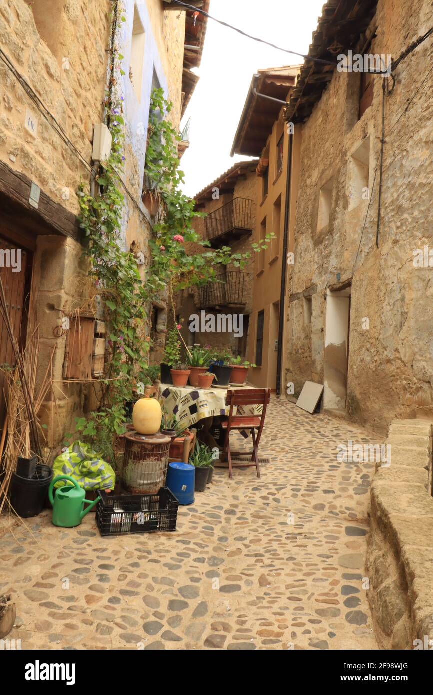 TERUEL, SPAIN - Sep 17, 2020: Table and chairs in a narrow stone street in a small medieval village in La Matarrana, Teruel (Spain) Stock Photo