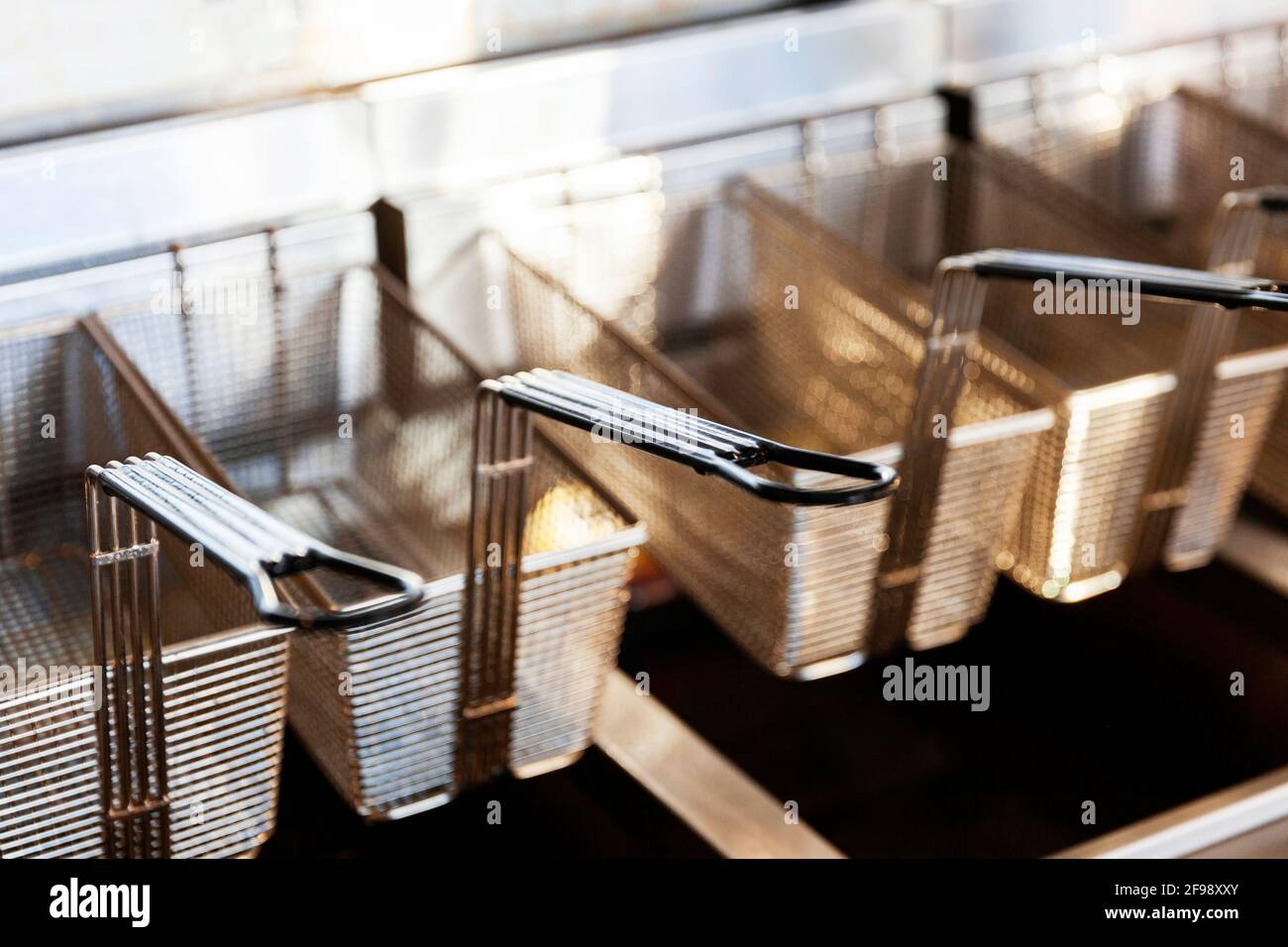 Stainless steel deep fryer wire baskets hanging on shelf Stock Photo ...