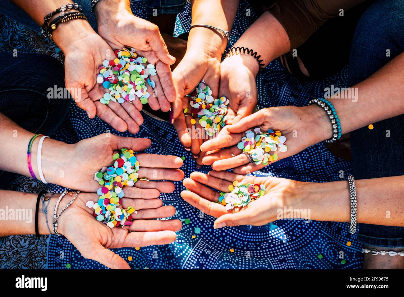 Close up of female hands full of confetti ready to celebrate together in friendship and team - women people and empowerment concept lifestyle Stock Photo