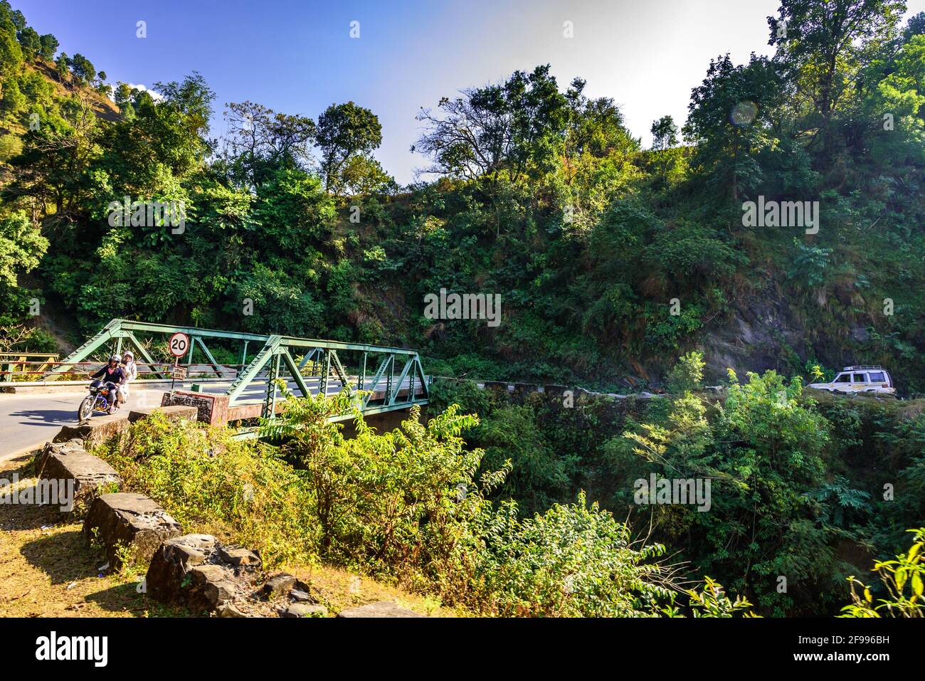 ALMORA, INDIA - NOVEMBER, 2018: Curvy mountainous road bridge over rivulet through green forest in  Uttarakhand, India. Stock Photo