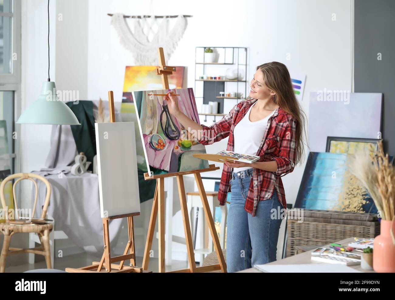 Young female artist painting in studio Stock Photo - Alamy