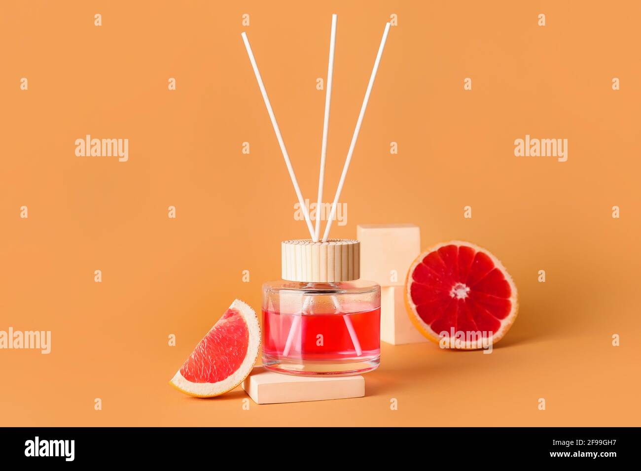 Reed diffuser with grapefruits on color background Stock Photo