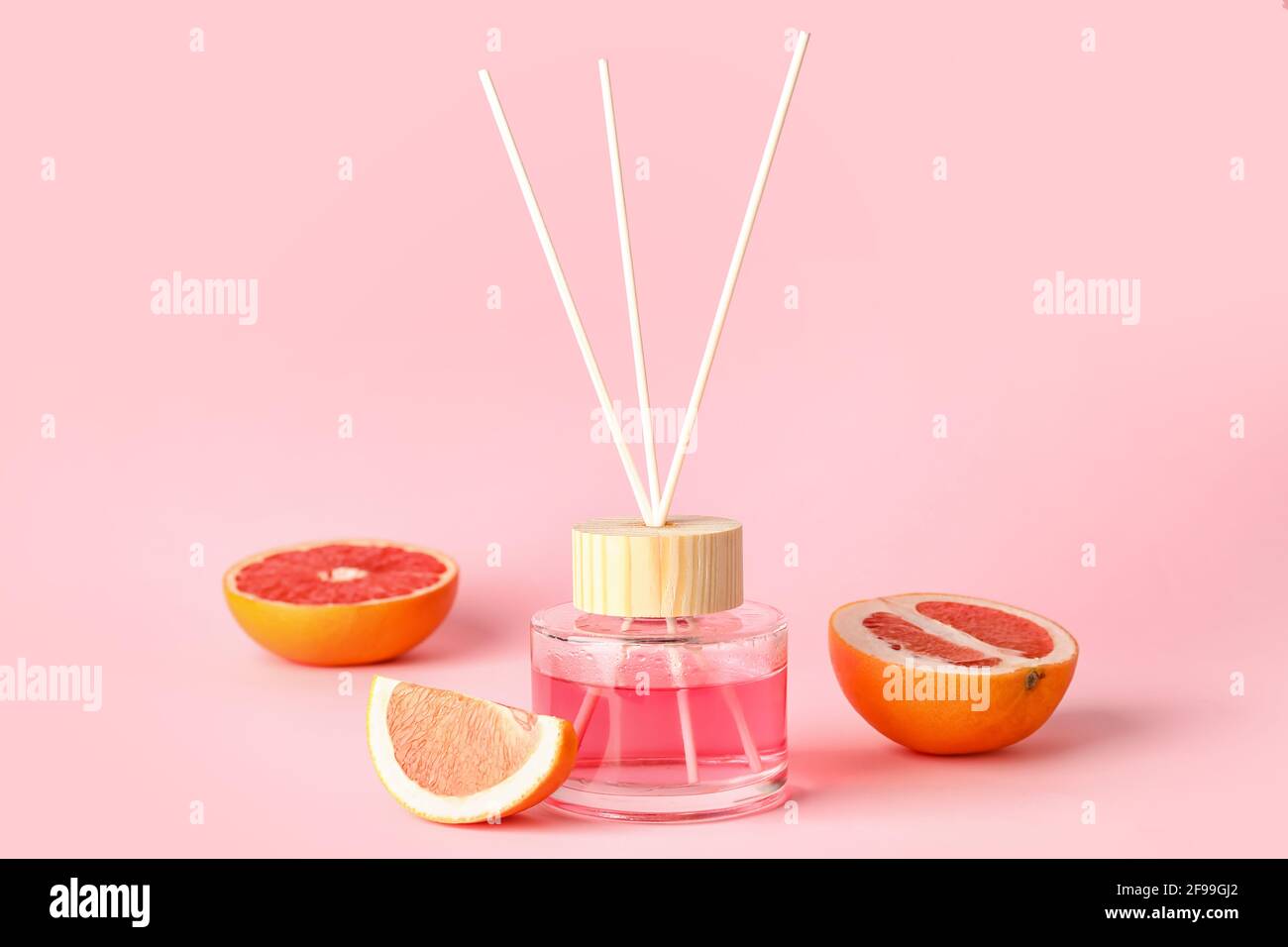 Reed diffuser with grapefruits on color background Stock Photo