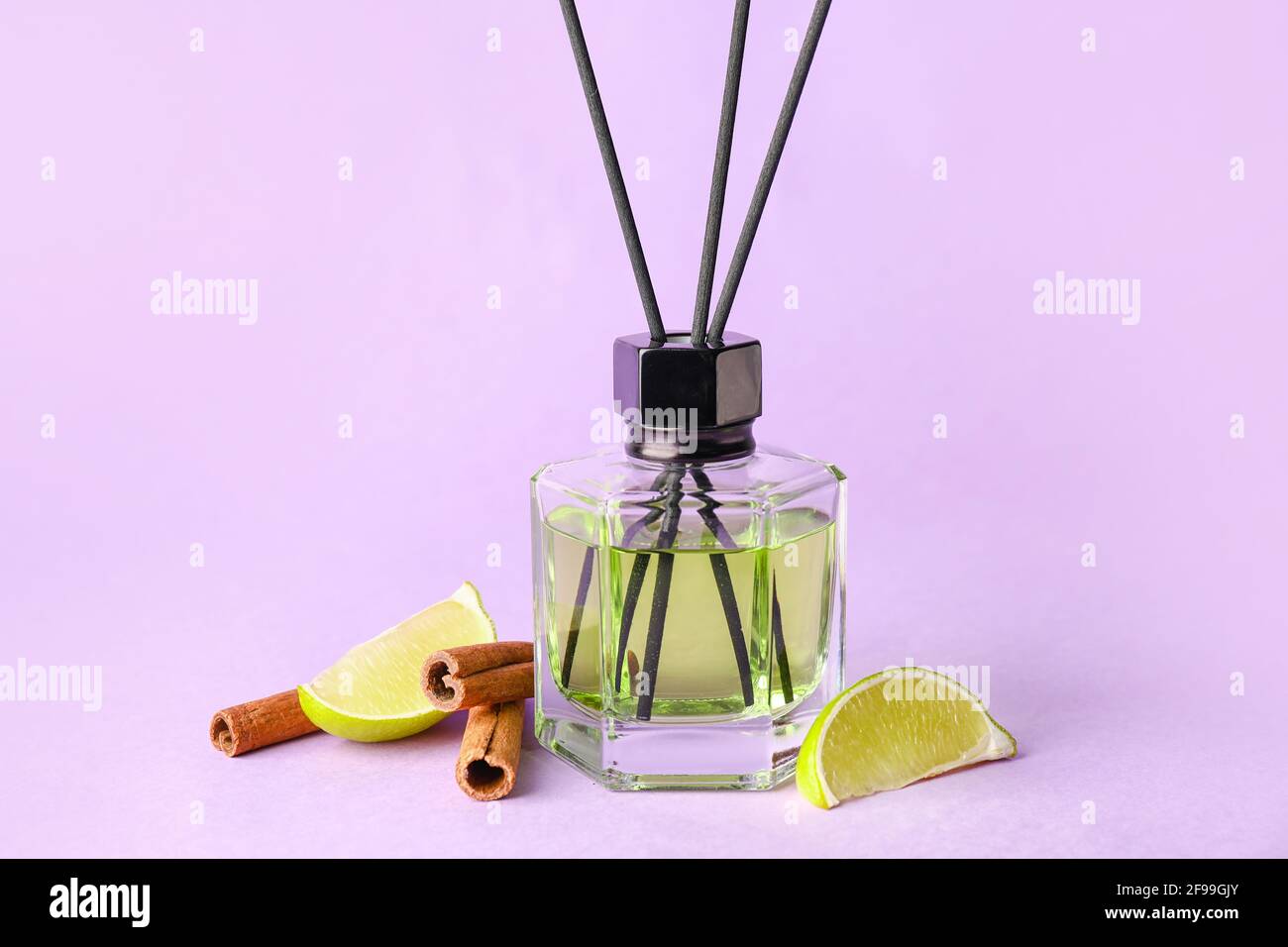 Reed diffuser with lime and cinnamon on color background Stock Photo