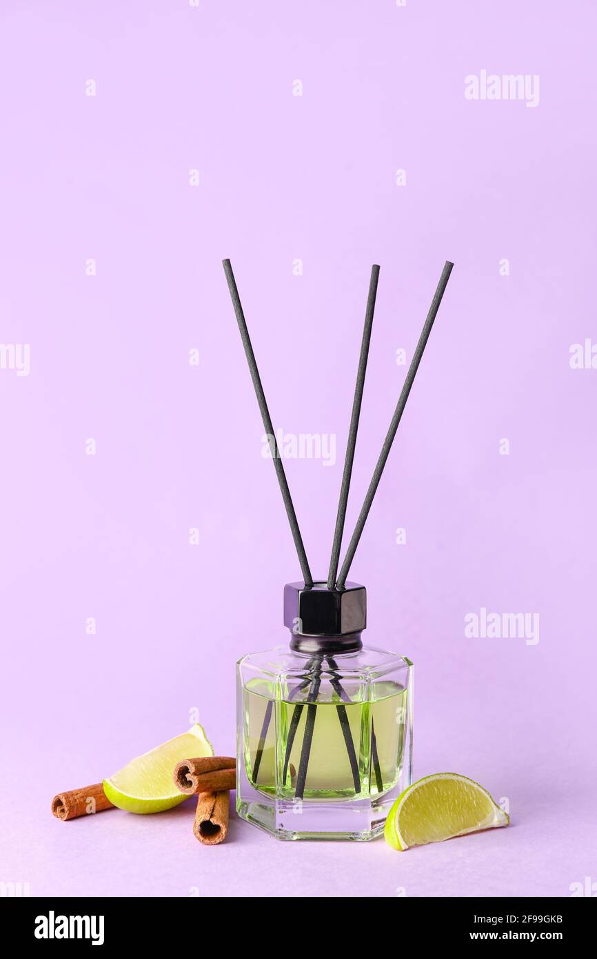 Reed diffuser with lime and cinnamon on color background Stock Photo
