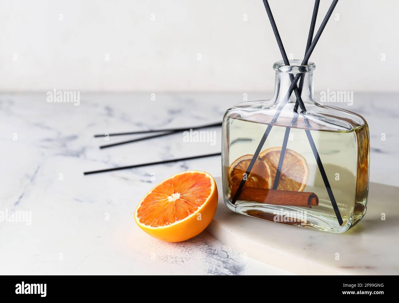 Citrus reed diffuser with cinnamon on light background Stock Photo