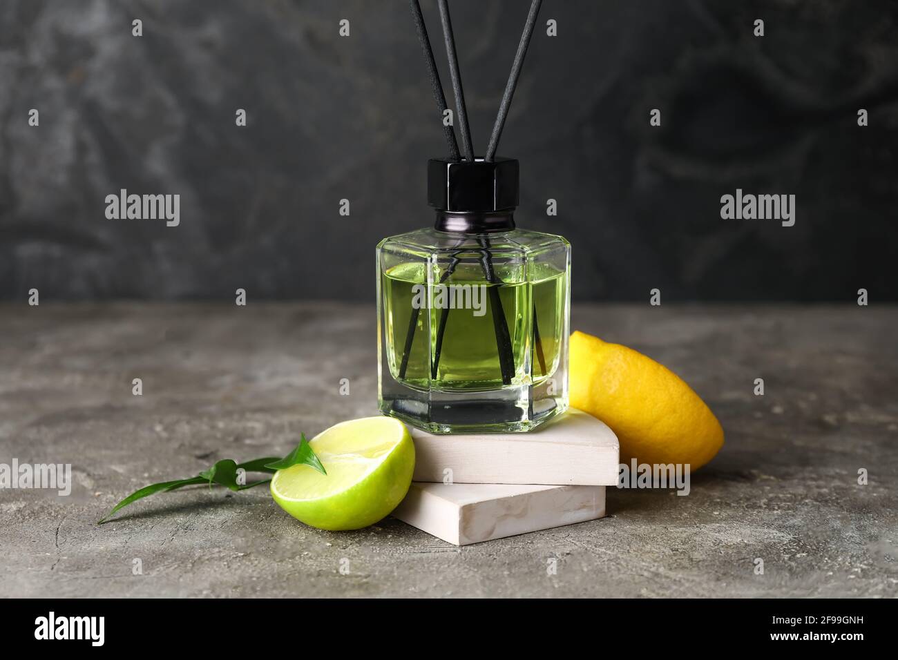 Reed diffuser with lemon and lime on grunge background Stock Photo