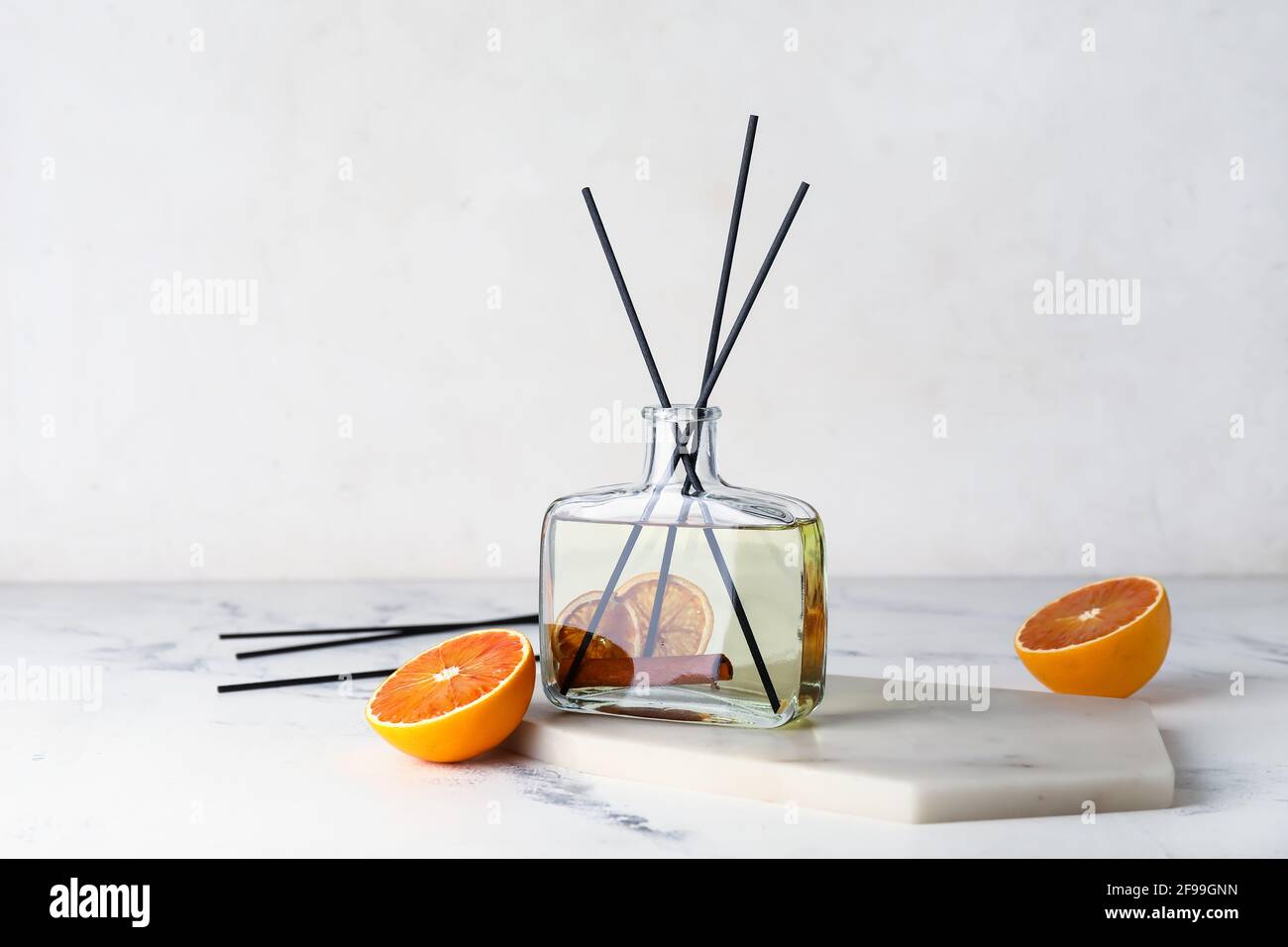 Citrus reed diffuser with cinnamon on light background Stock Photo