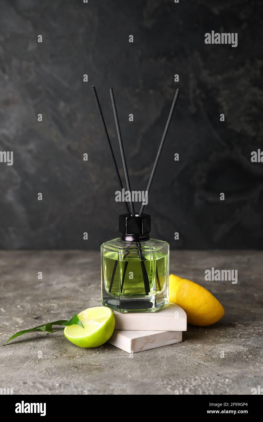 Reed diffuser with lemon and lime on grunge background Stock Photo