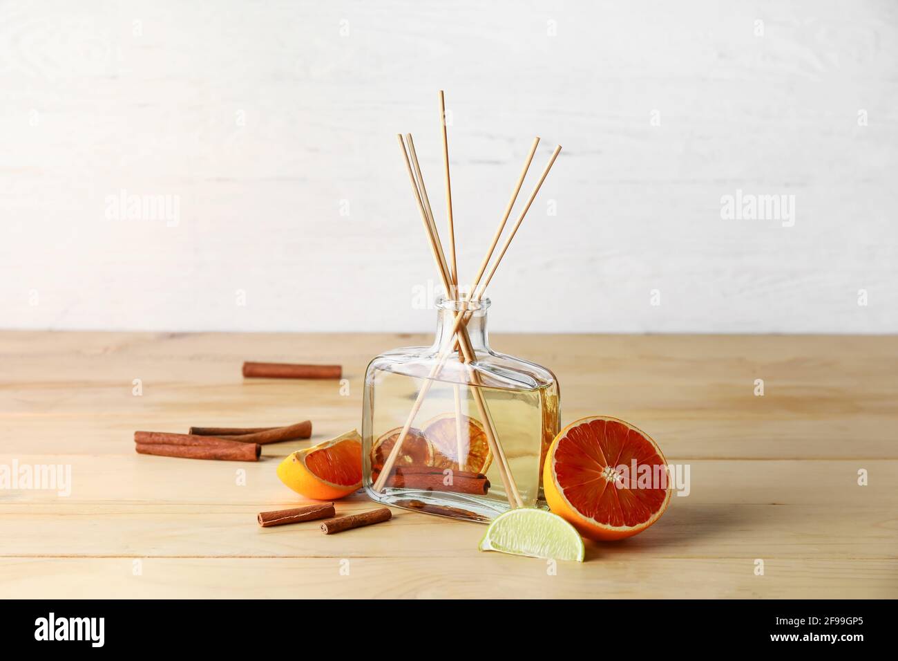 Reed diffuser with grapefruit and cinnamon on wooden table Stock Photo