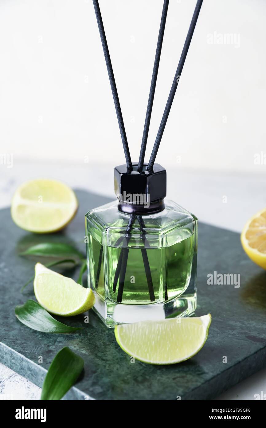Reed diffuser with lemon and lime on light background Stock Photo