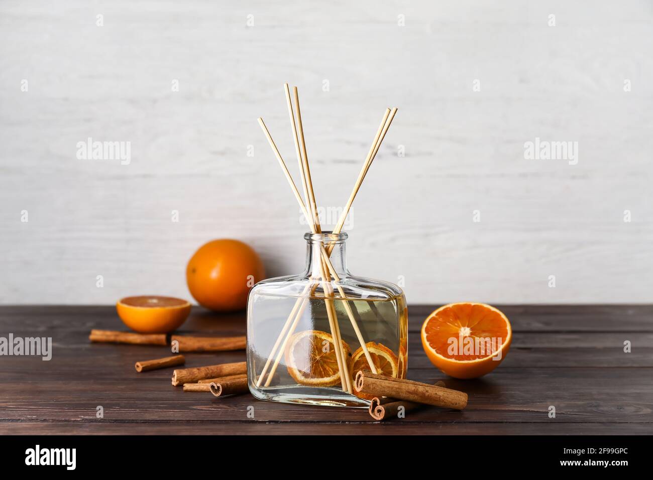 Citrus reed diffuser with cinnamon on wooden table Stock Photo
