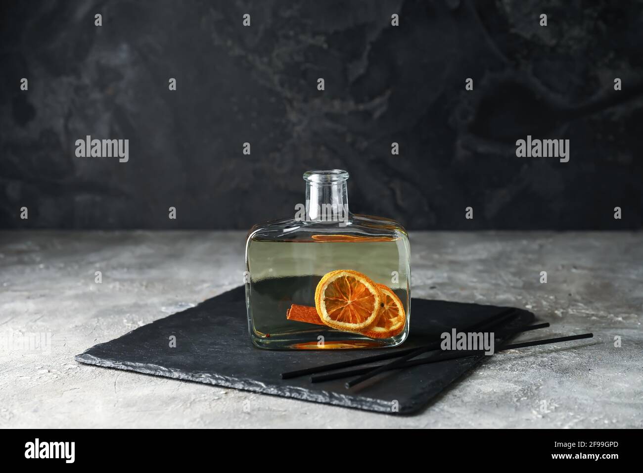 Reed diffuser with orange and cinnamon on grunge background Stock Photo