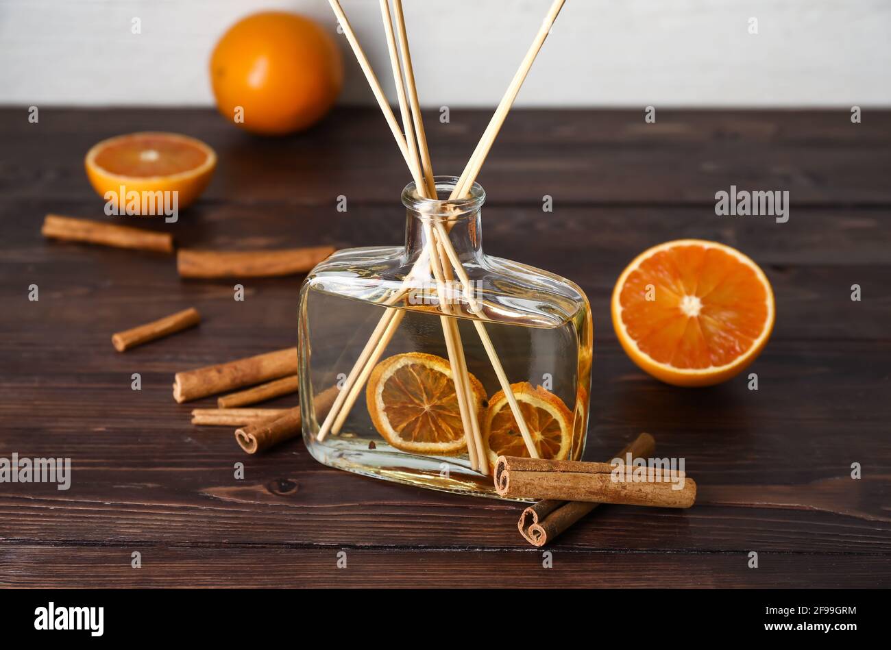 Citrus reed diffuser with cinnamon on wooden table Stock Photo
