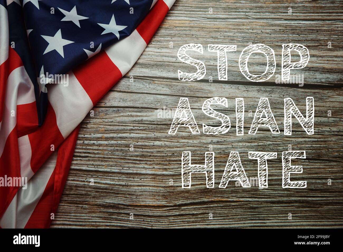 Stop Asian Hate text with USA flag on wooden background Stock Photo