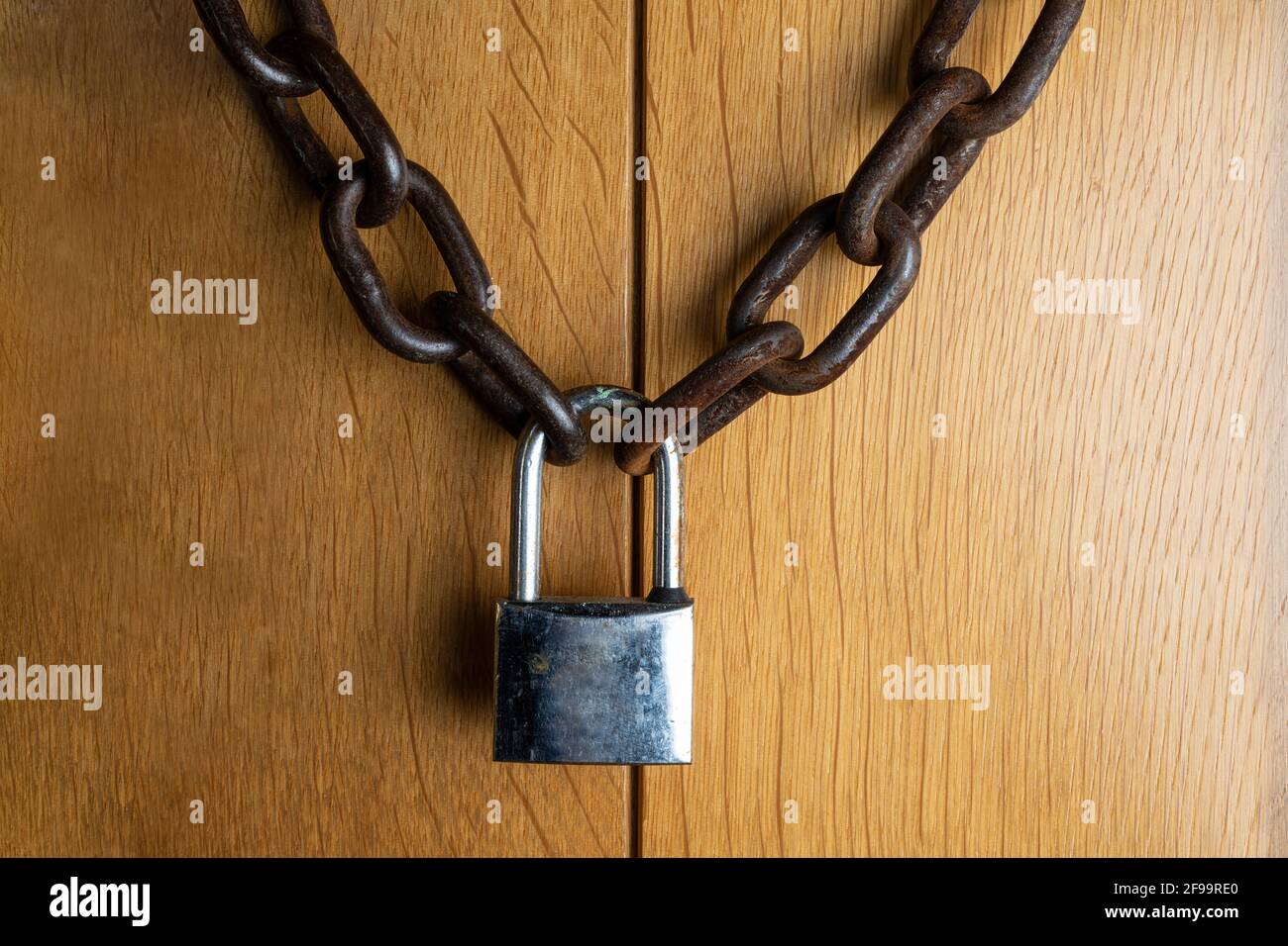 the wooden door closed with the chain and padlock Stock Photo