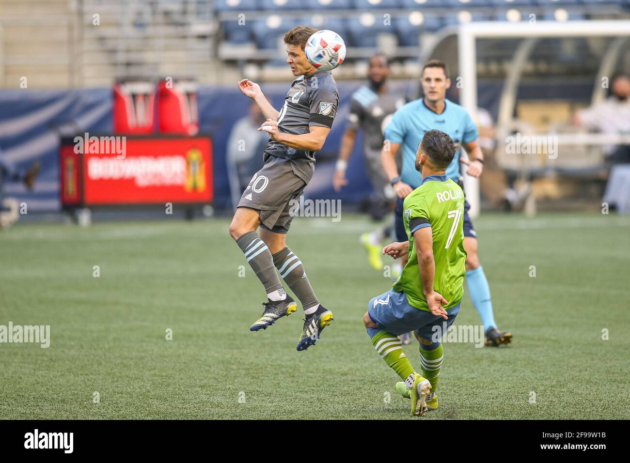 Minnesota United FC midfielder Wil Trapp (20) heads the ball against Seattle Sounders FC midfielder Cristian Roldan (7) during the first half of an ML Stock Photo