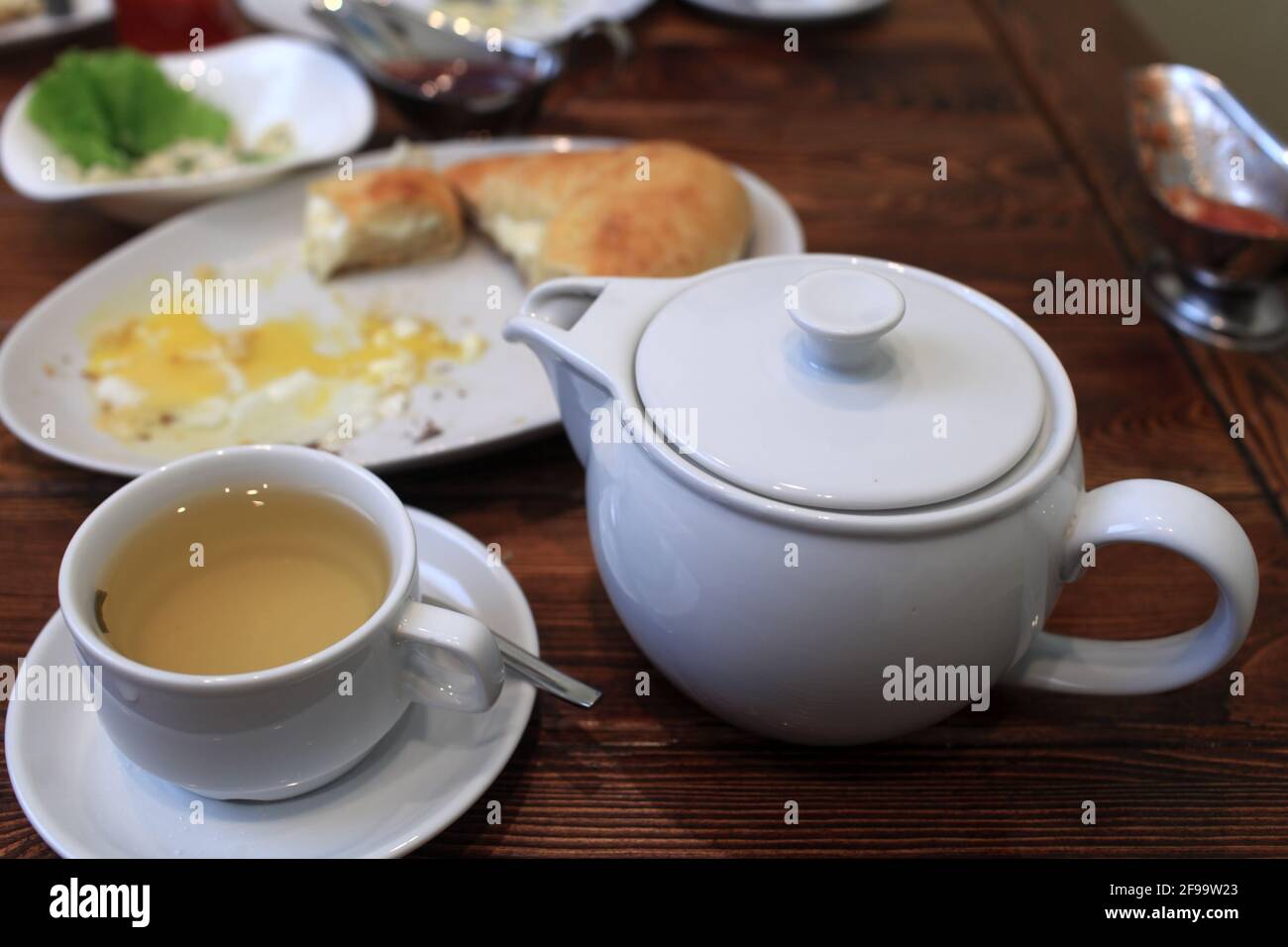 White teapot and cup of green tea in a restaurant Stock Photo