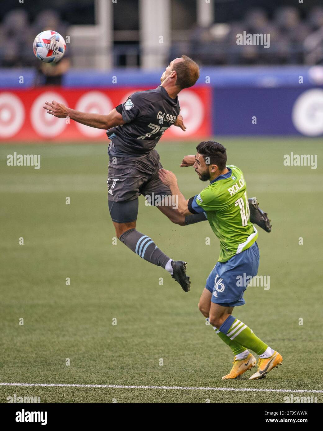 Minnesota United FC defender Chase Gasper (77) leaps for the ball past Seattle Sounders FC midfielder Alex Roldan (16) during the first half of an MLS Stock Photo