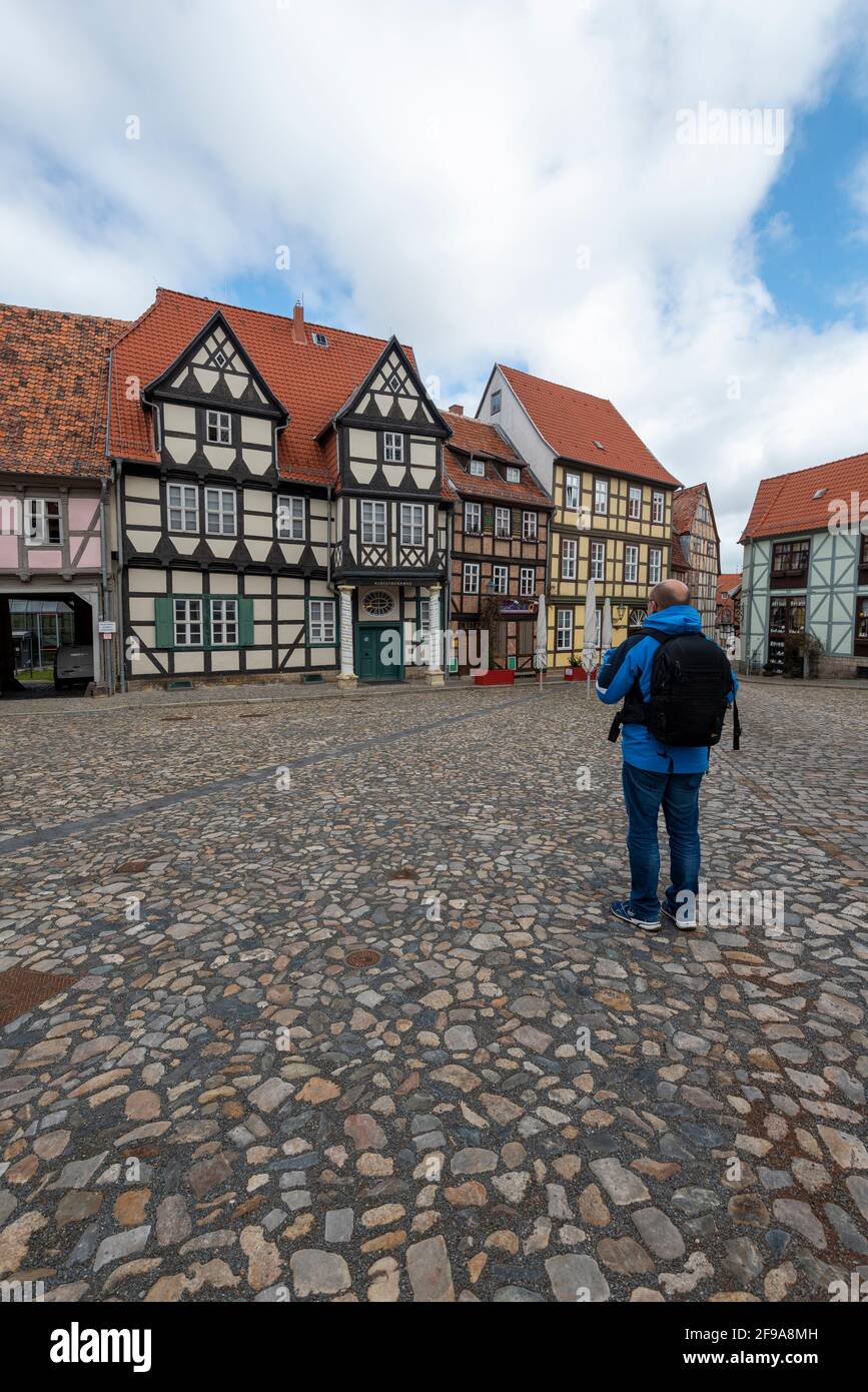 Germany, Saxony-Anhalt, Quedlinburg, a tourist stands in front of the Klopstock house and other half-timbered houses on the Schlossberg, World Heritage City of Quedlinburg. Stock Photo