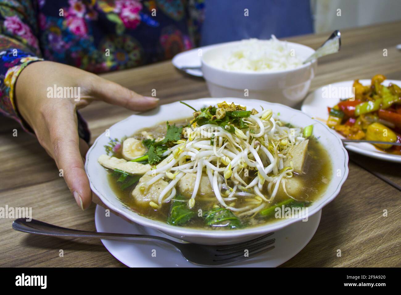 A Woman Hand Holding A Bowl Of Thai Chicken Meatball Soup In A Restaurant Stock Photo Alamy