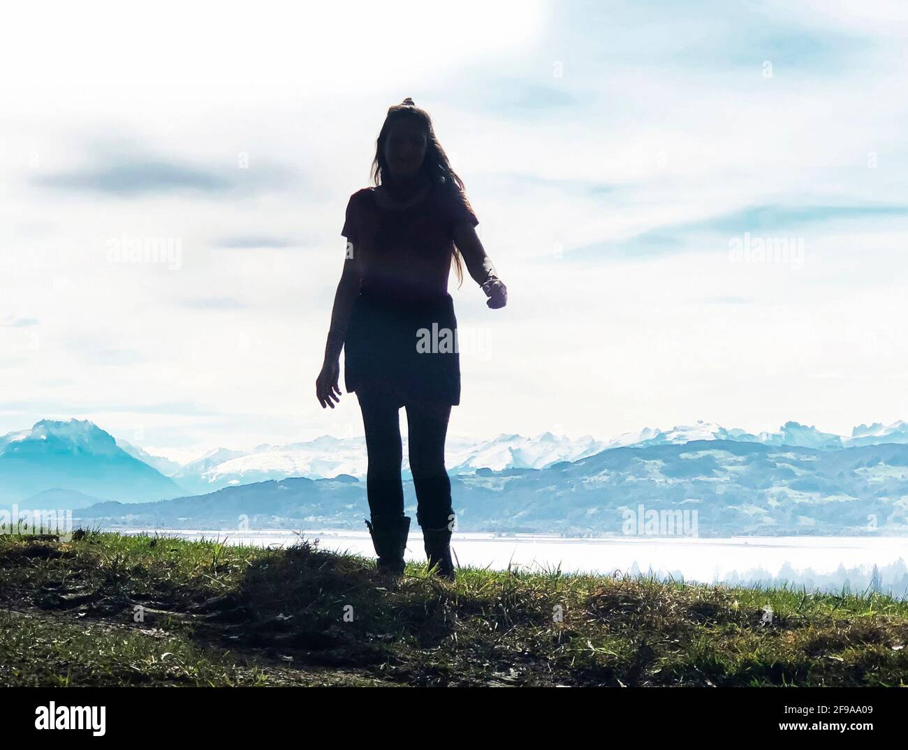 Young woman with long hair in front of Lake Constance panorama in the backlight Stock Photo