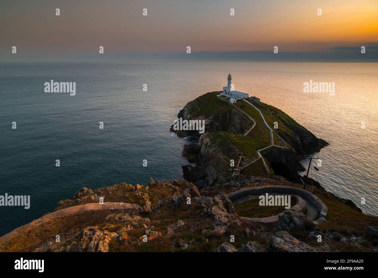 South Stack Lighthouse on small headland in the light of sunset Stock Photo