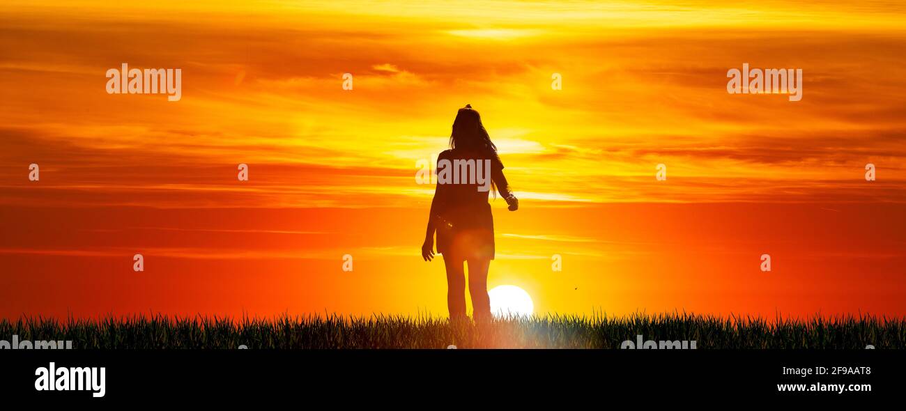 Silhouette of a woman with long hair before sunset Stock Photo