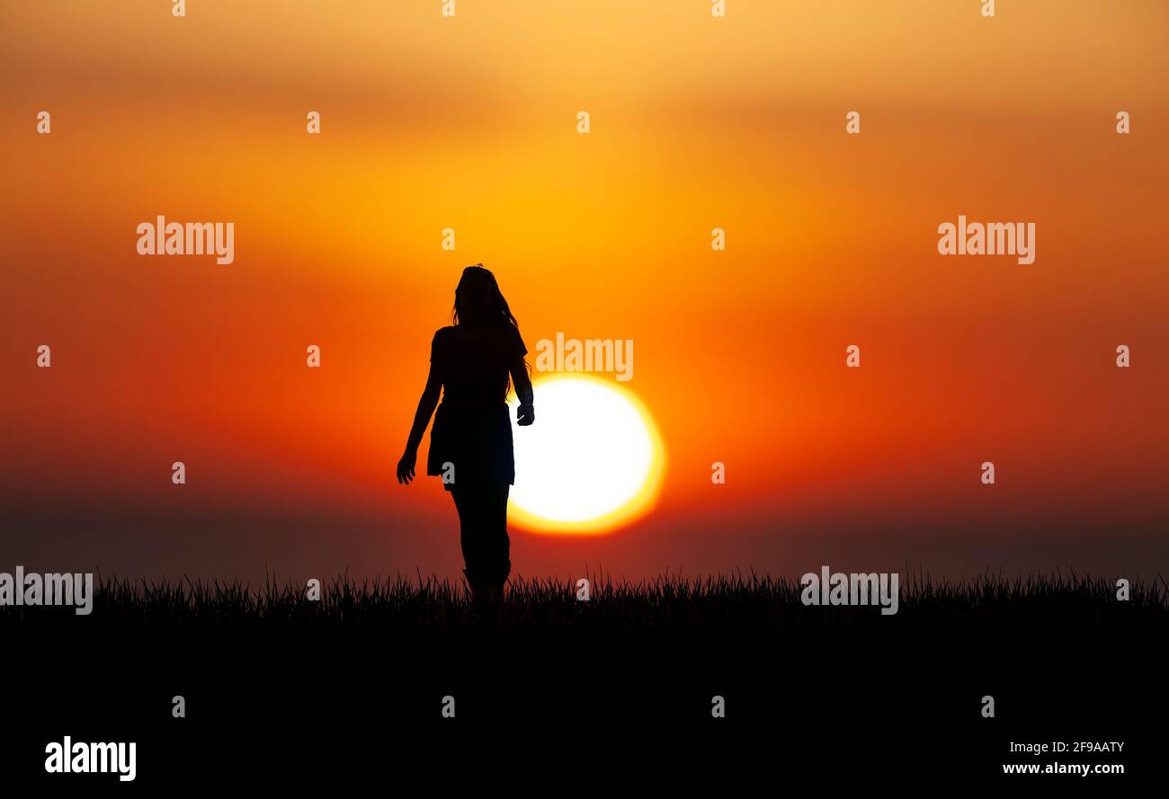 Silhouette of a woman with long hair before sunset Stock Photo