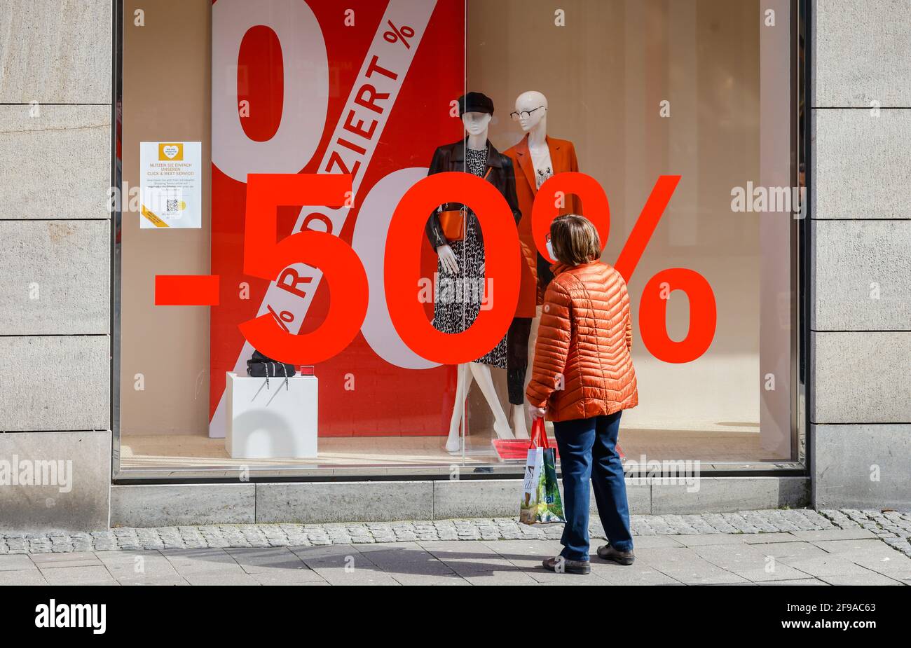 Essen, North Rhine-Westphalia, Germany - discount battle in the corona crisis, retail sales in times of the corona pandemic at the second lockdown, shops in NRW are partially open subject to conditions, Click & Meet, register online and make a shopping appointment, poster in the shop window Reduced, 50 percent discount. Stock Photo