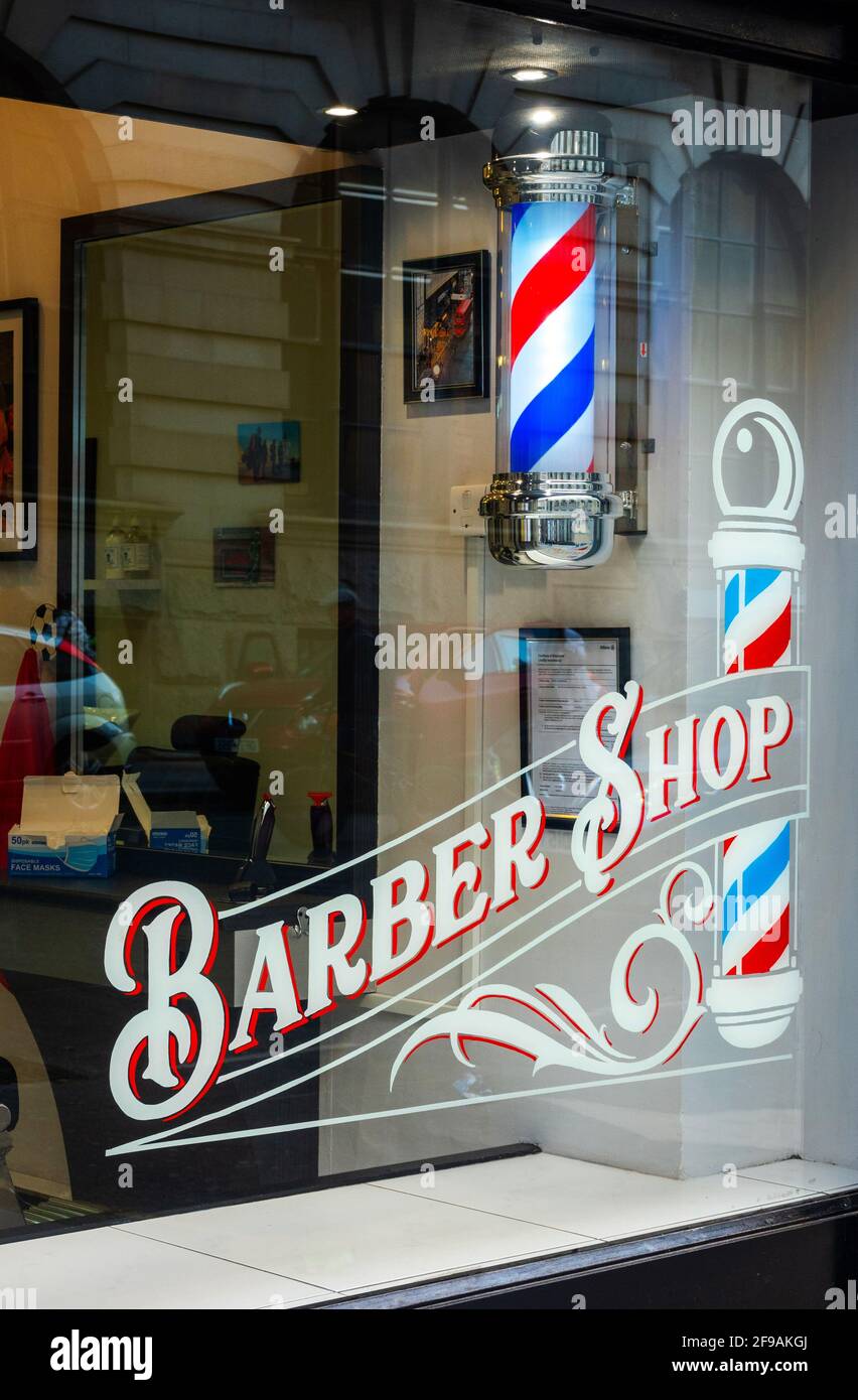 Barber Shop window and red, white, and blue barber pole. Stock Photo