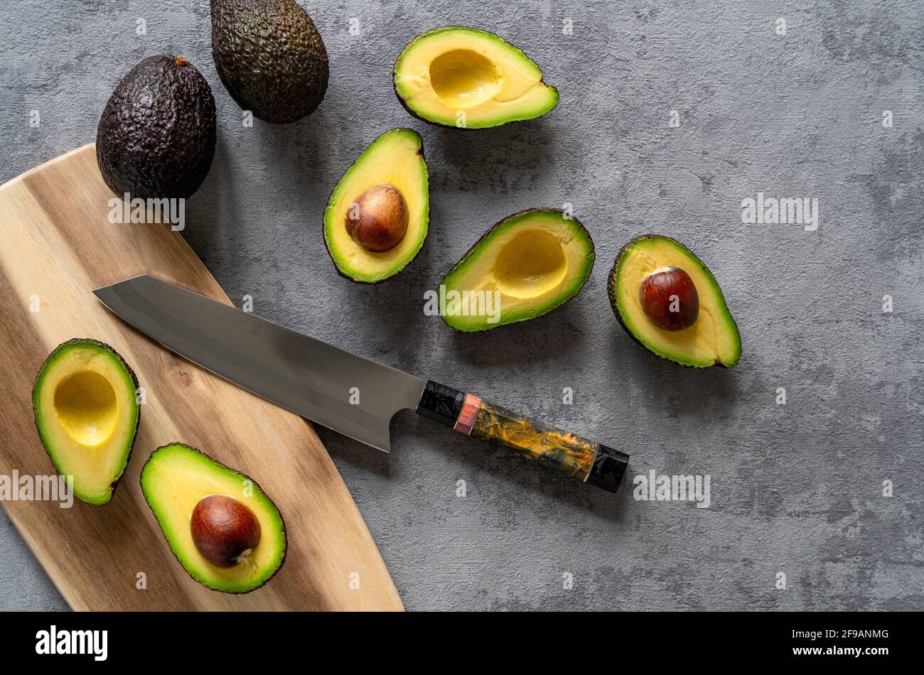 Chopped Avocados In A Bowl On Cutting Board On Wooden Background. Half  Avocado With Pulp And Seed, Whole Green Fresh Tropical Fruit On Brown  Table, Top View Stock Photo, Picture and Royalty