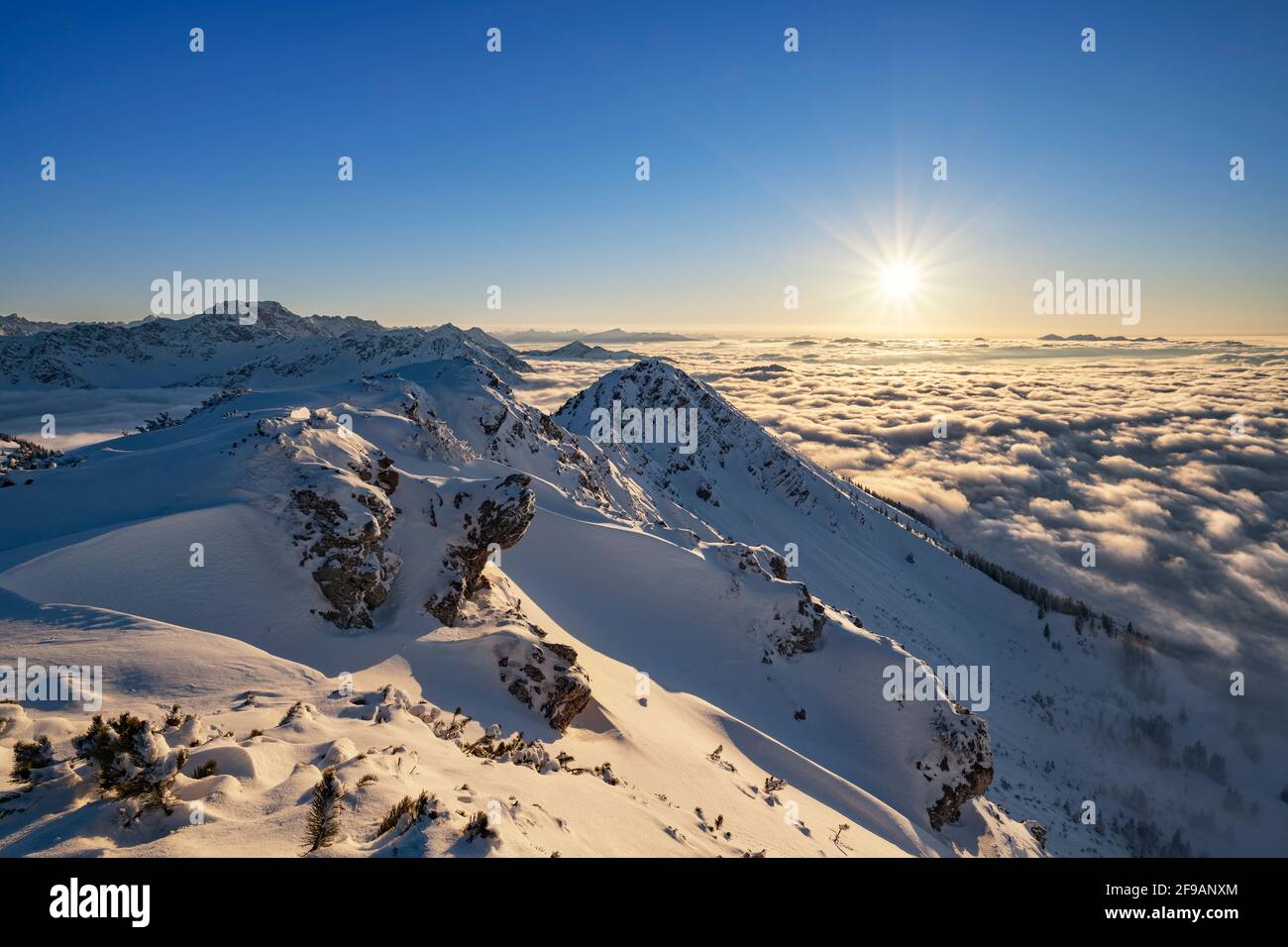 Winter mountain landscape at sunset over sea of clouds. View from Kühgundkopf to the Allgäu Alps. Bavaria, Germany, Europe Stock Photo