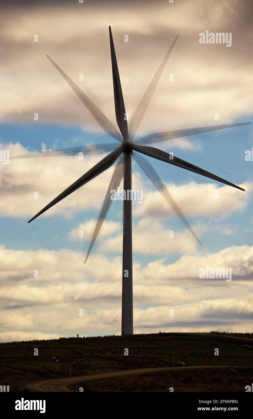 A wind turbine, with it blades ghosted in different positions to suggest the concept of renewable power generation Stock Photo
