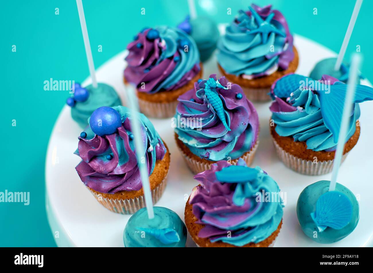 Cream muffins decorated with a nautical theme. Homemade cakes, blue and violet butter cream. Selective focus on decoration Stock Photo