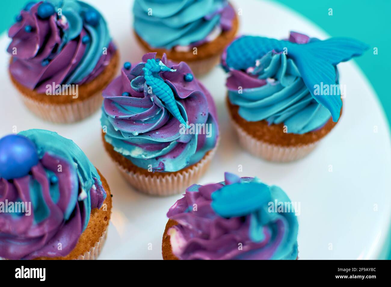 Cream muffins decorated with a nautical theme. Homemade cakes, blue and violet butter cream. Selective focus on decoration Stock Photo