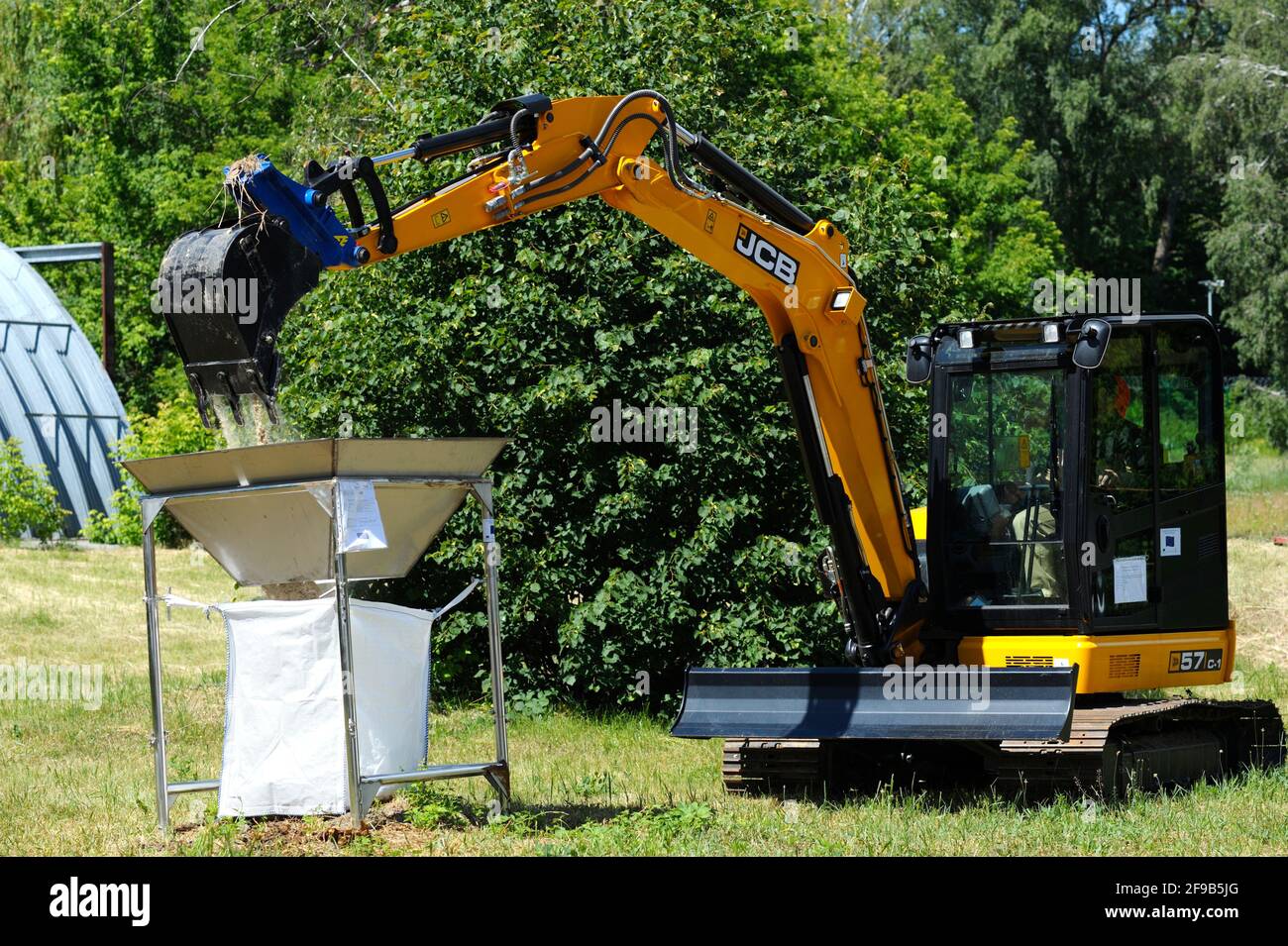 Bobcat loading sand into a radioactive waste storage container. October 1, 2018. State corporation Radon . Kiev, Ukraine Stock Photo