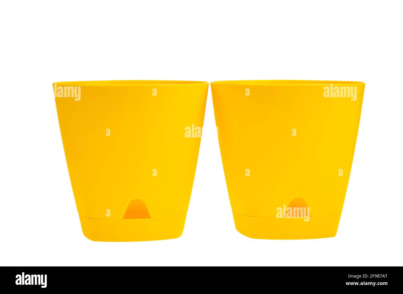Yellow empty plastic flower pots isolated on white background. Studio