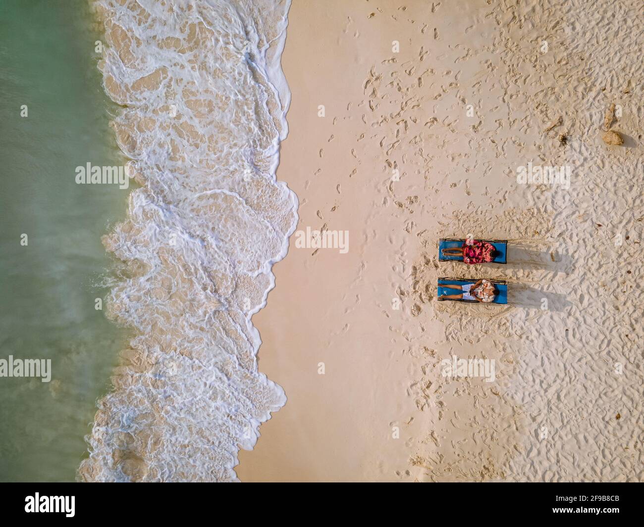 Aruba Caribbean couple man and woman mid age on vacation on the beach with palm trees on the beach Stock Photo