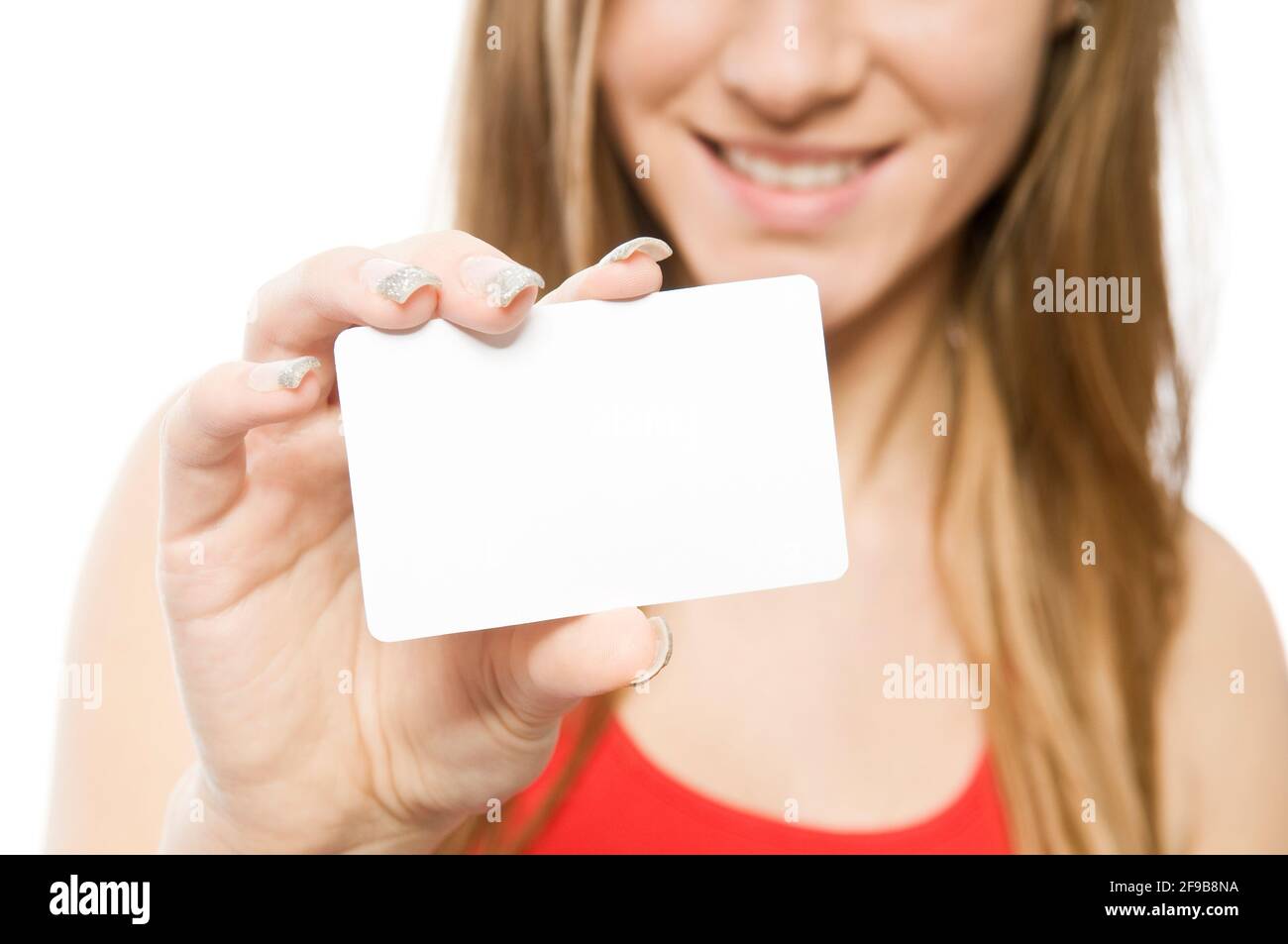 Young happy woman with long brown hair in red shirt holding blank business or credit card with copy space for your advertising text message. Isolated Stock Photo