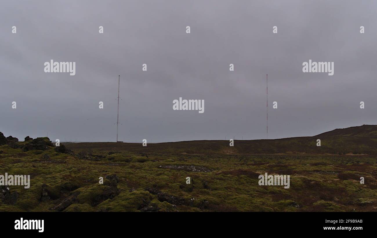 View of the Naval Radio Transmitter Facility (NRTF) of the US Navy with two towers located between moss covered lava fields near Grindavík, Iceland. Stock Photo