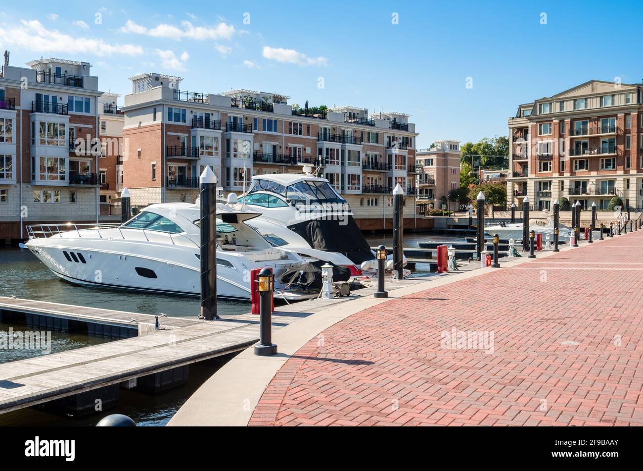 Yachts in a marina surrounded by modern apartment buildings on a sunny autumn day Stock Photo